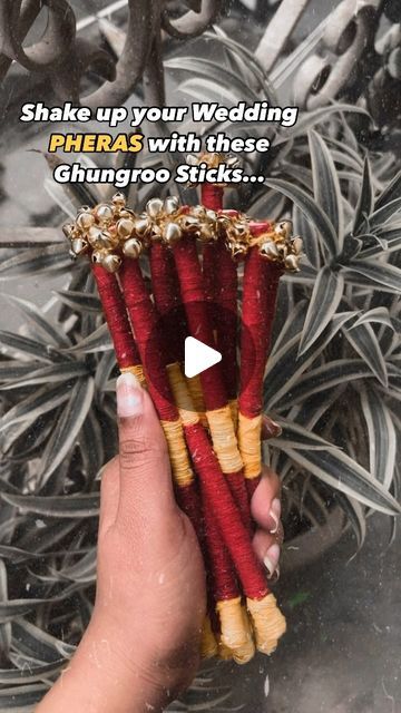 a person holding up some red and yellow flowers with words on the bottom that read, shake up your wedding pheras with these ghungo sticks