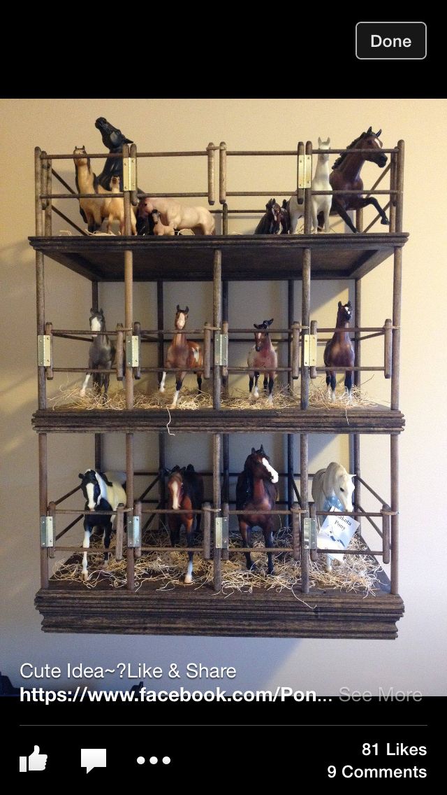 there are many toy horses on top of the shelves in this display case that is made out of wood