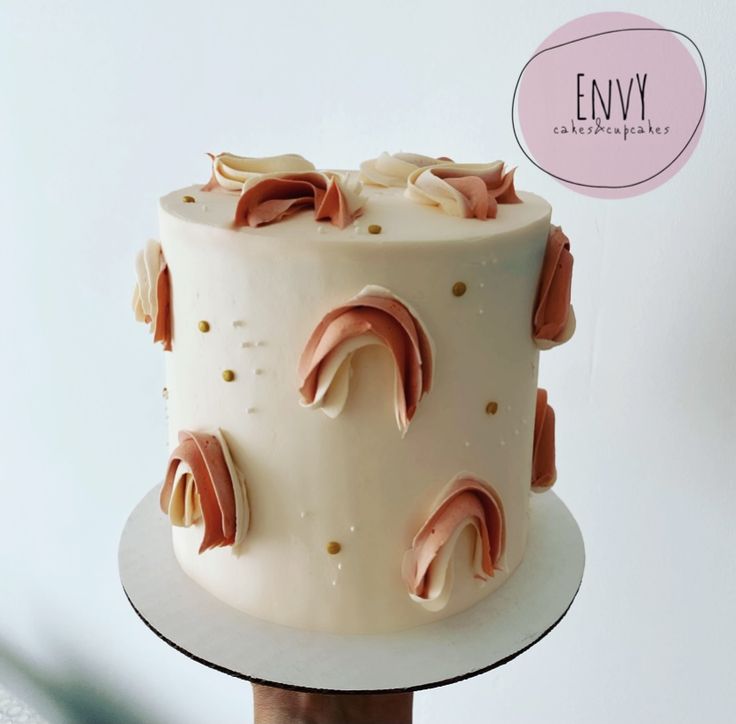 a white cake with pink icing and gold decorations