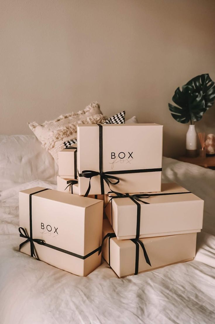 four boxes with bows tied around them sitting on a bed