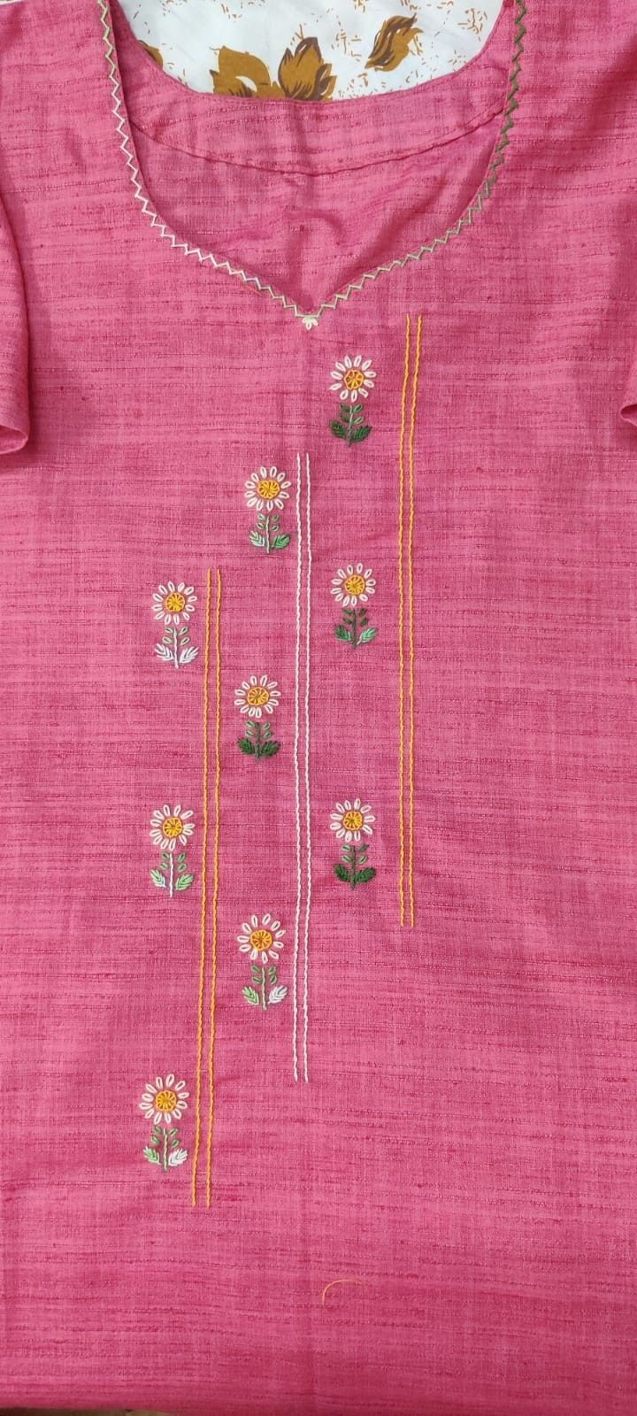 a pink shirt with daisies on it