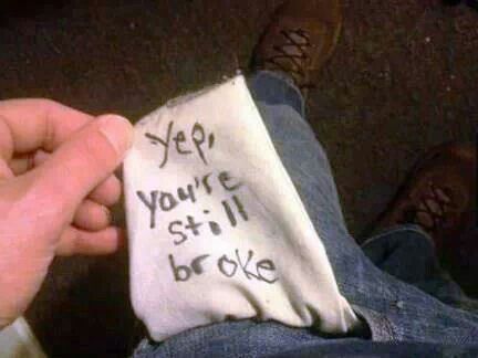 someone holding up a t - shirt that says, stop you're still broke