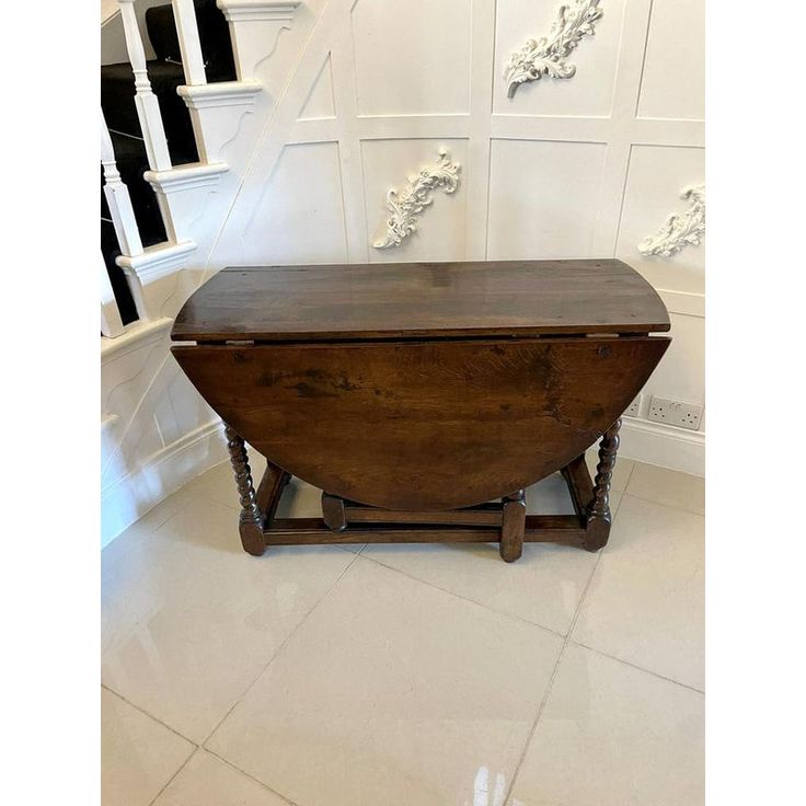 an old wooden chest sitting on top of a white tiled floor next to some stairs