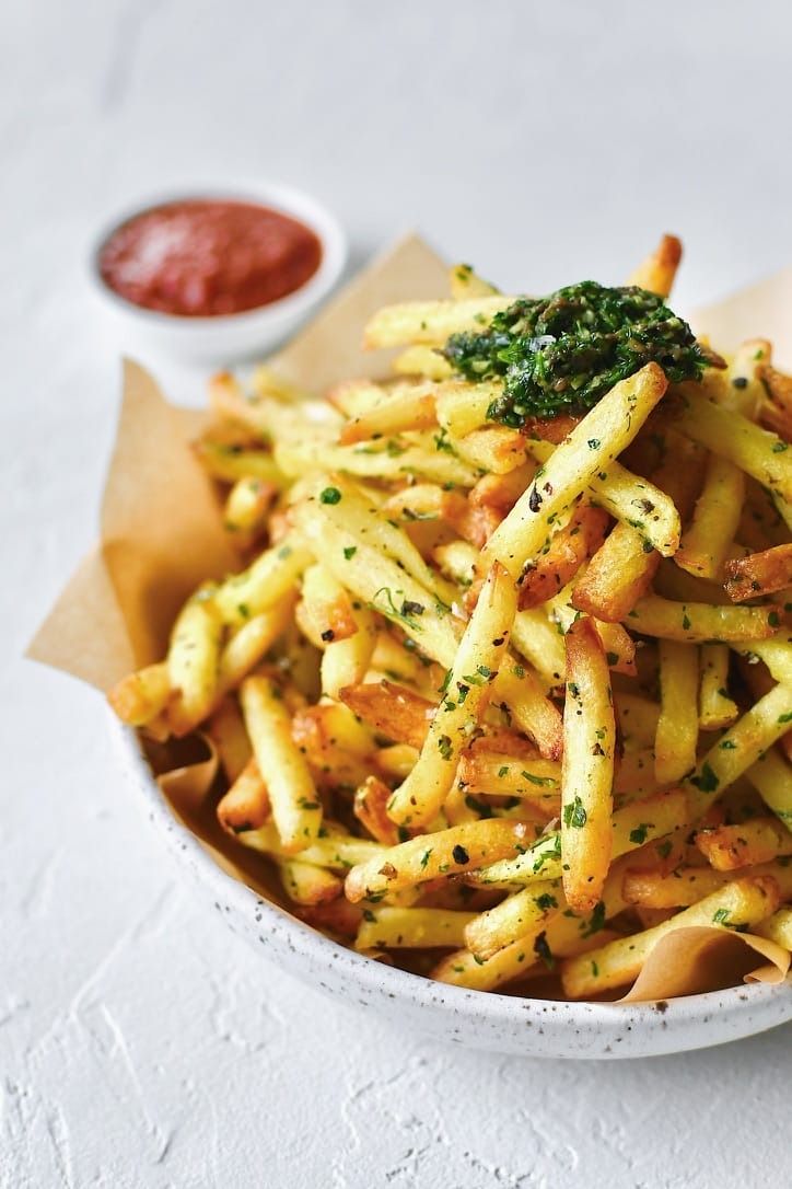 a white bowl filled with french fries and sauce