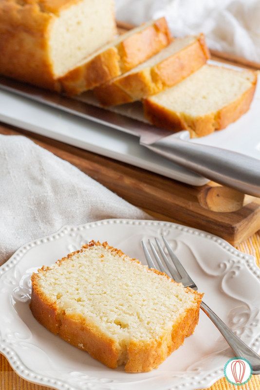 a loaf of pound cake on a plate with a fork and knife next to it