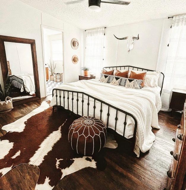 a bed sitting on top of a hard wood floor next to a white and brown rug