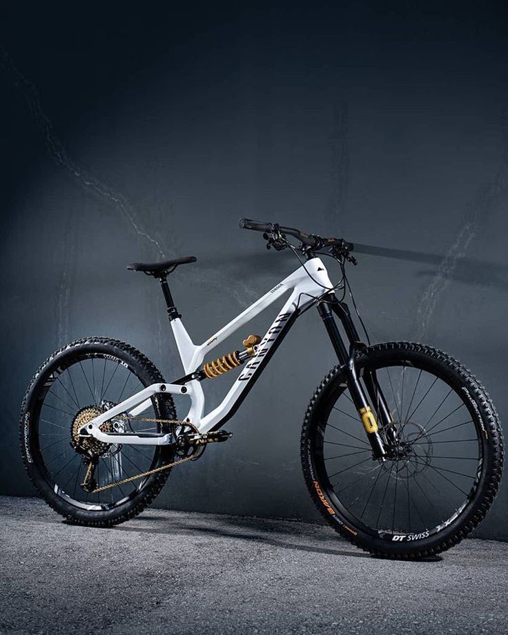 a white and black bike is shown against a dark background, with the wheels still on