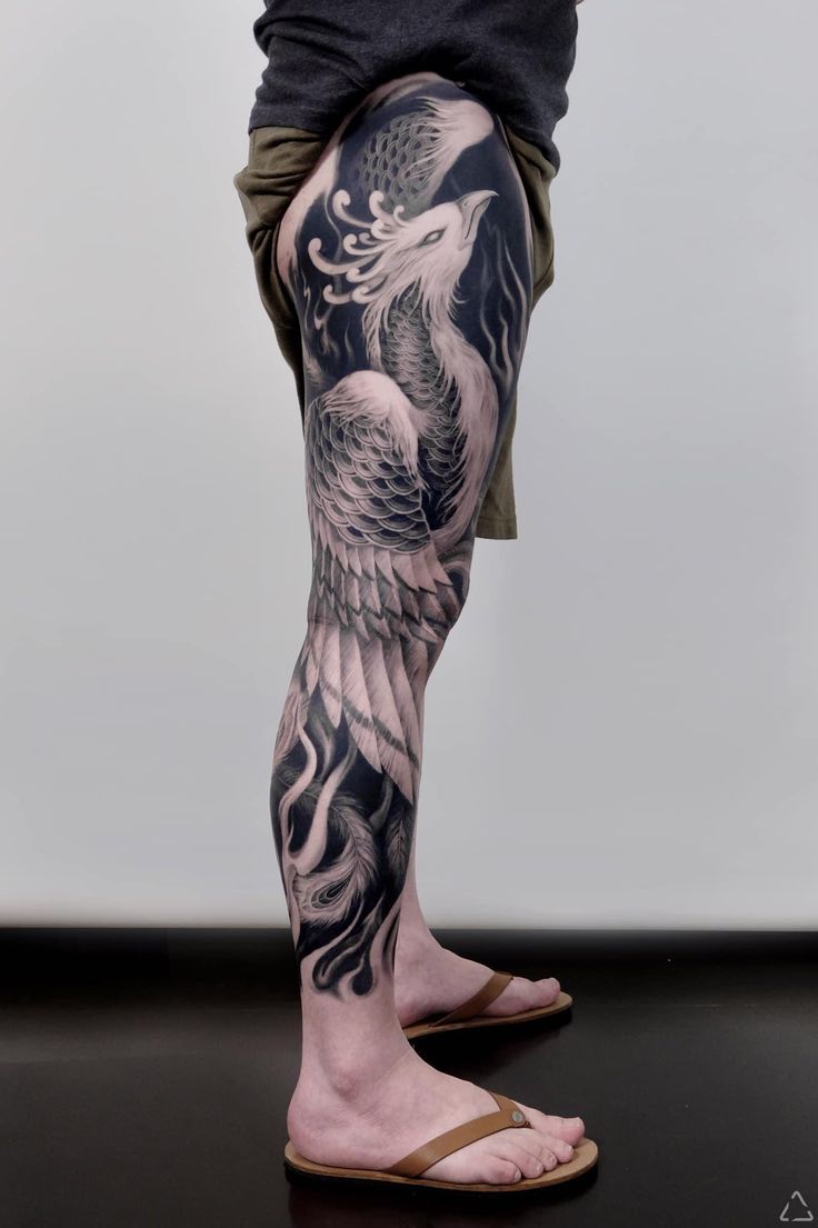 a man's legs with tattoos on them and an eagle in the middle of his leg