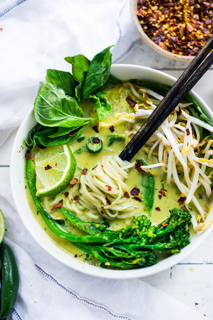 a bowl filled with noodles, broccoli and other vegetables