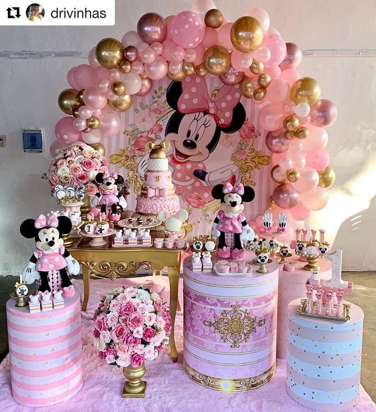 a table topped with lots of pink and gold cake next to balloons in the shape of minnie mouse