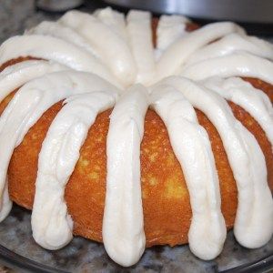 a bundt cake with white icing on a glass plate