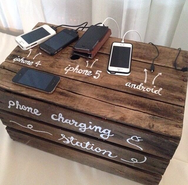 a wooden box with writing on it and two cell phones attached to the top one