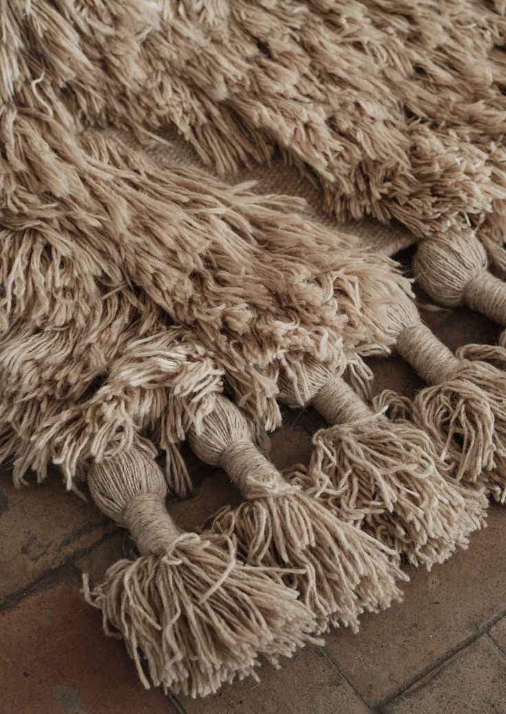 a pile of shaggy rugs laying on top of a brick floor