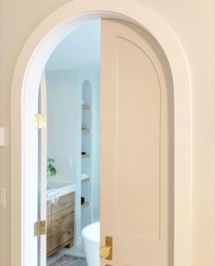 an open door leading to a bathroom with a tub