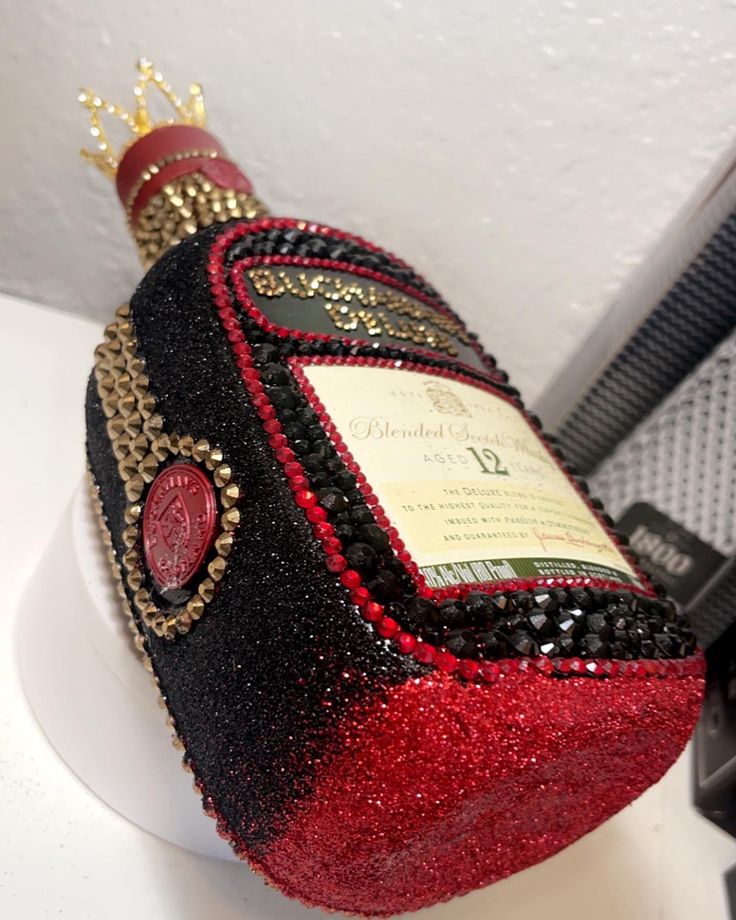 a red and black wine bottle sitting on top of a counter