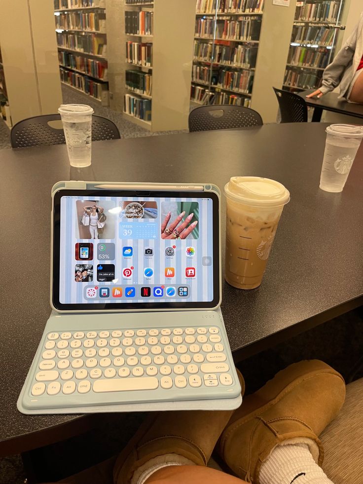 an open laptop computer sitting on top of a table next to a cup of coffee