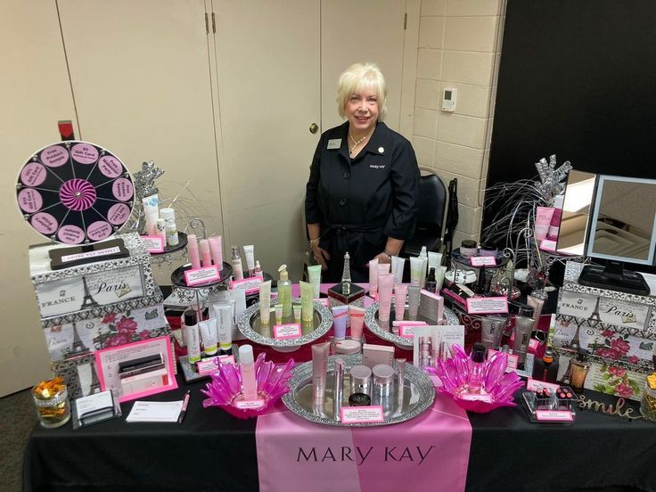 a woman standing next to a table full of beauty products