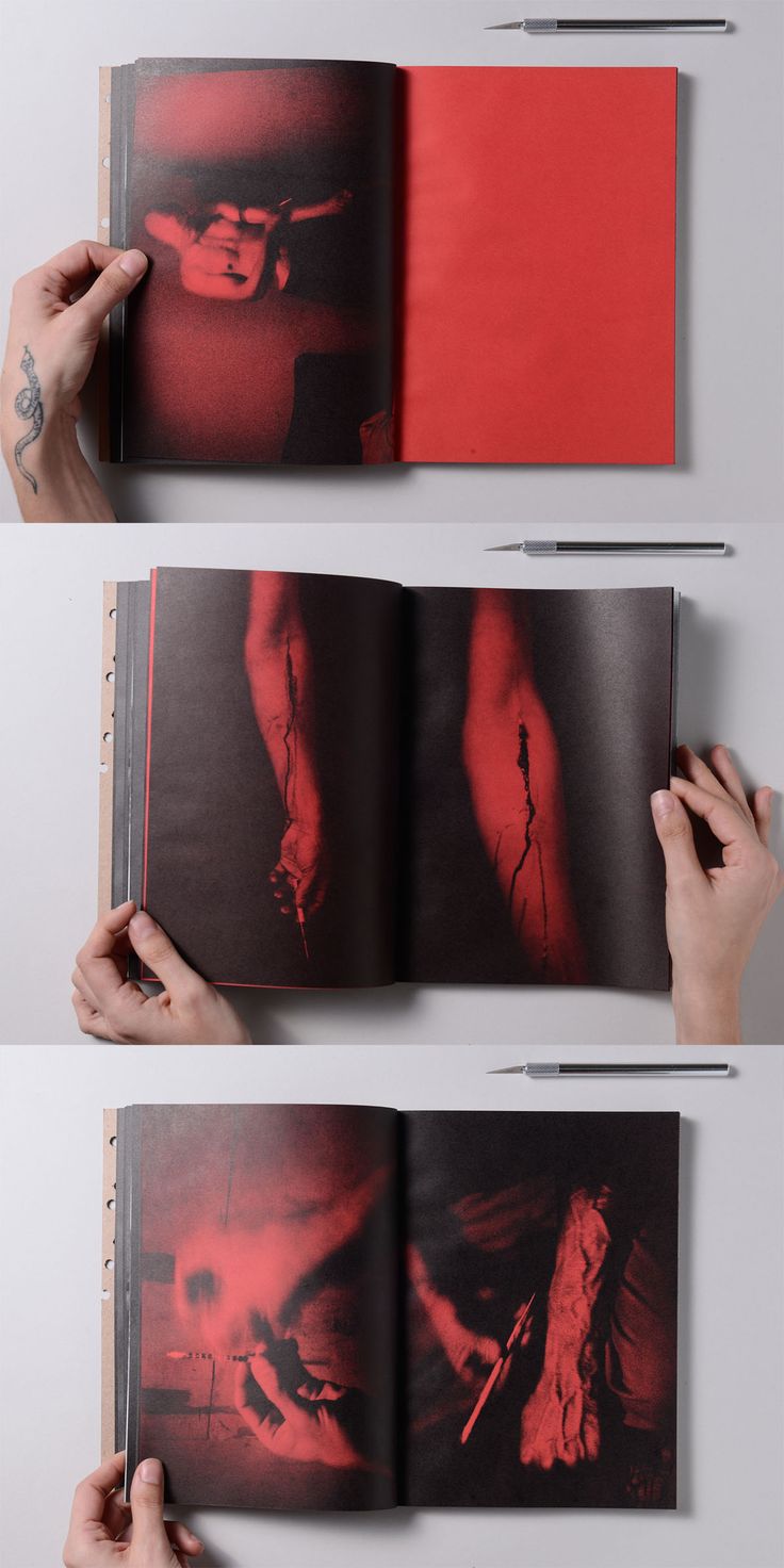 two hands holding an open book with red images on it