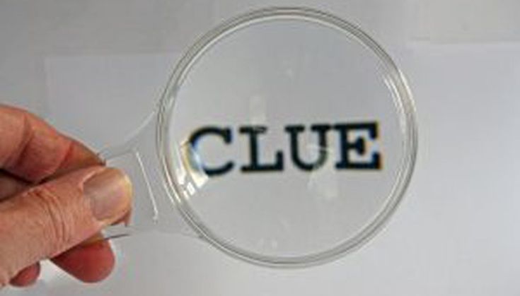 a hand holding a magnifying glass with the word clue under it, in front of a white background