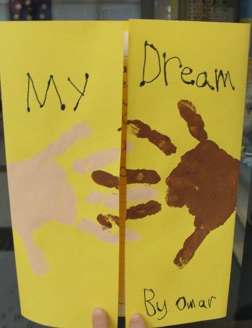 a child's hand holding up a book with the words my dream written on it