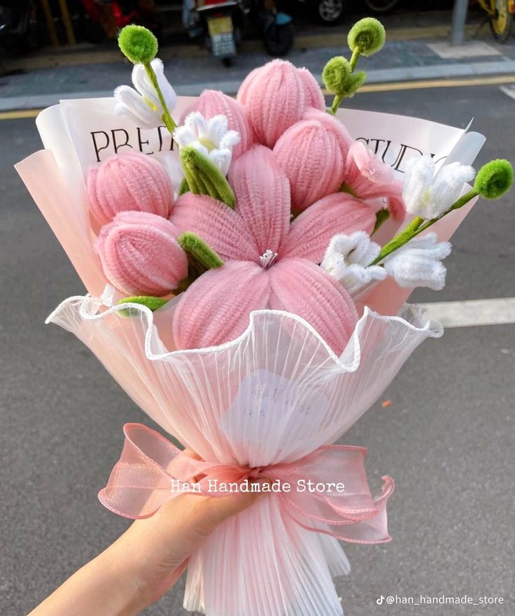 a person holding a bouquet of pink and white flowers in their hand with the words pretti written on it