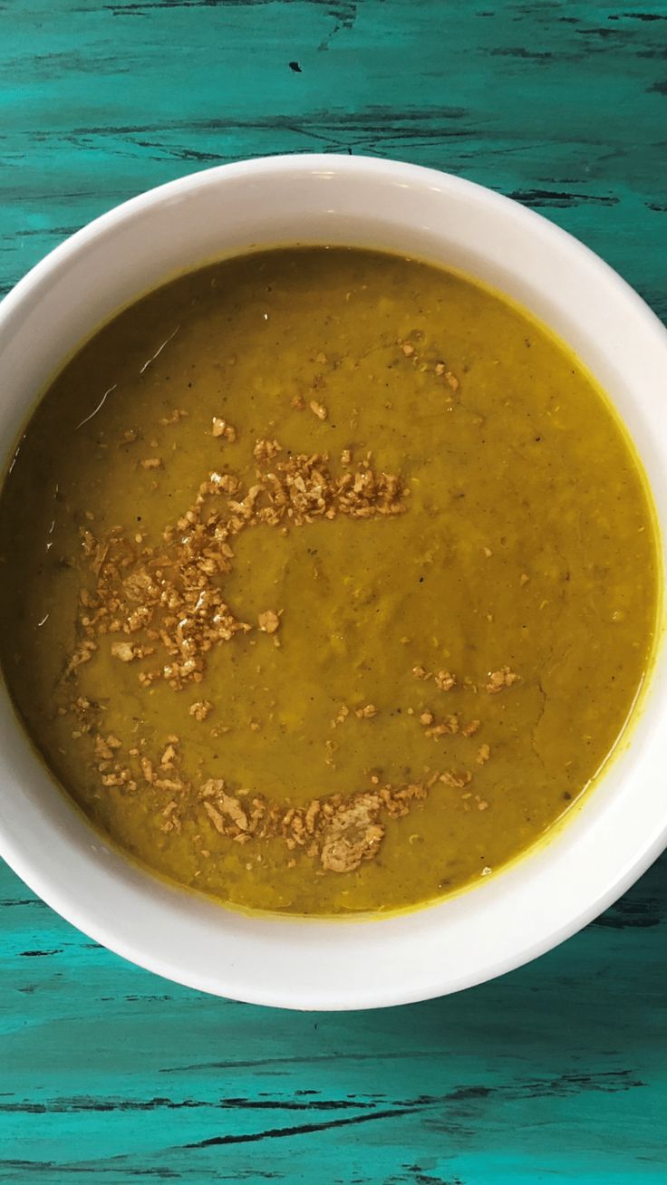 a white bowl filled with soup on top of a blue table