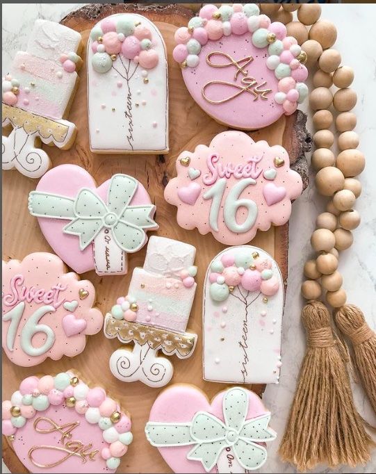 decorated cookies are displayed on a tray with beads, tassels and other decorations