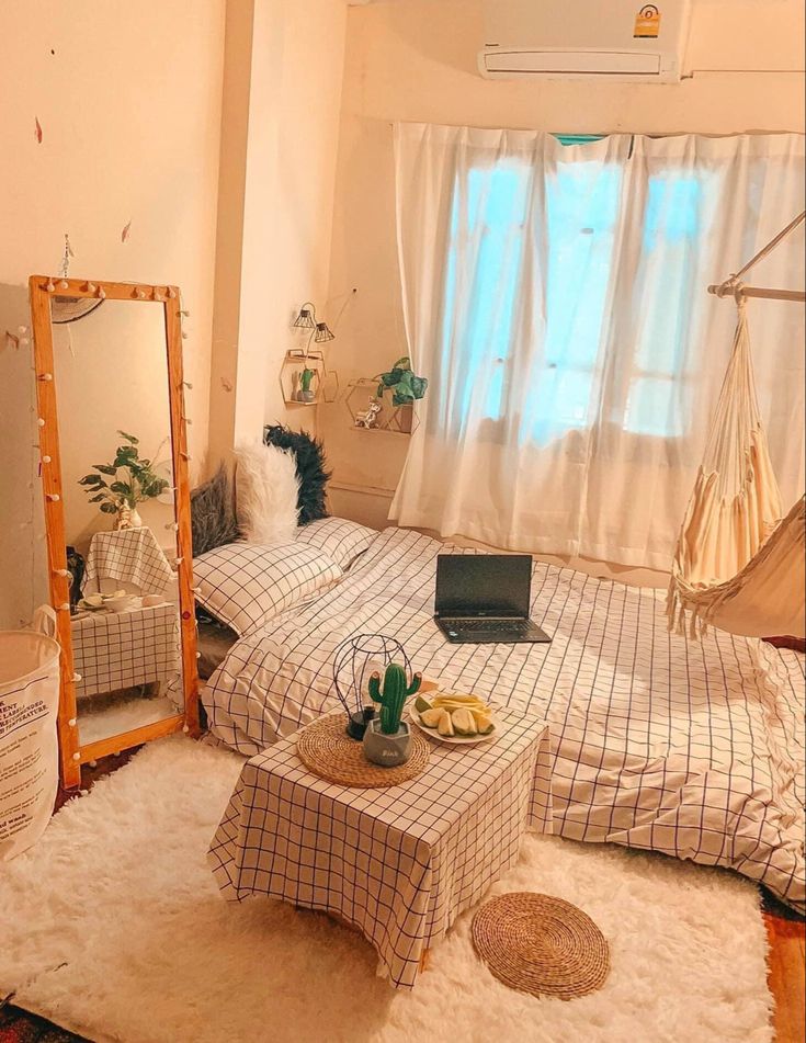 a bed room with two beds and a laptop on top of a table in front of a window