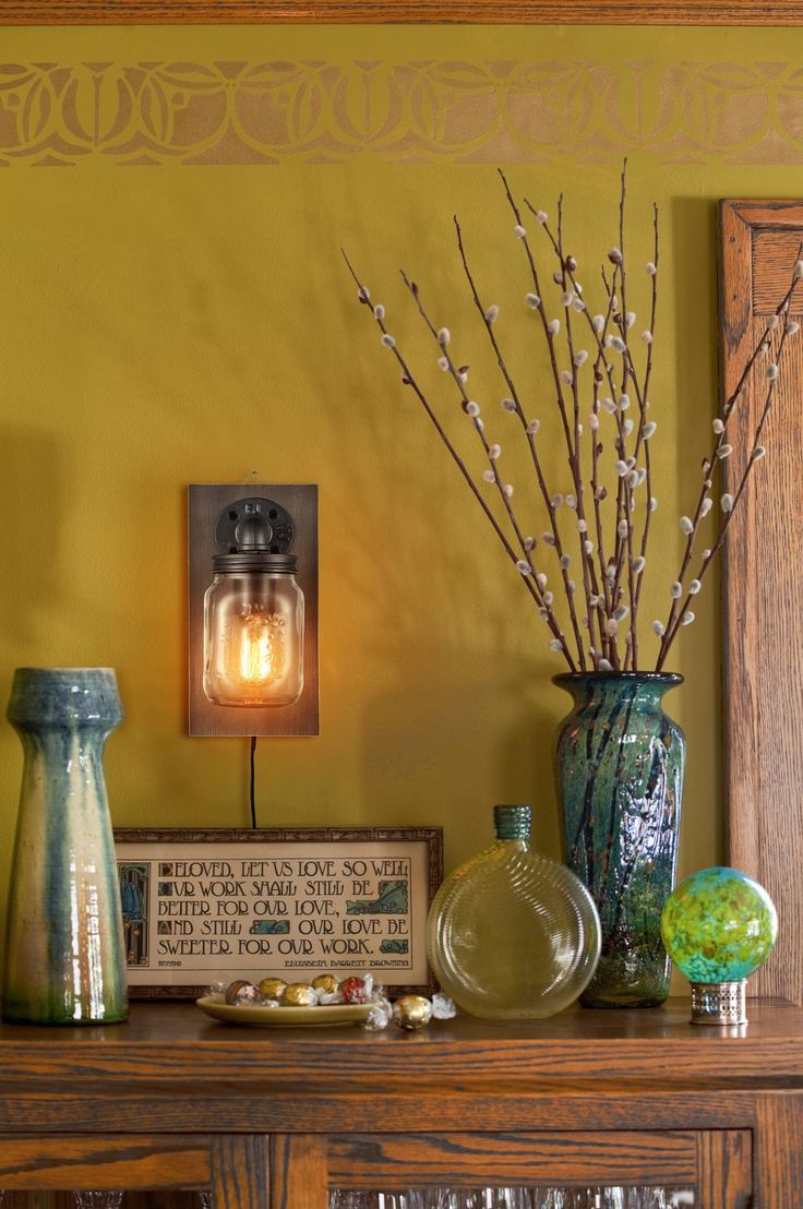 vases and other decorative items sit on a table in front of a yellow wall