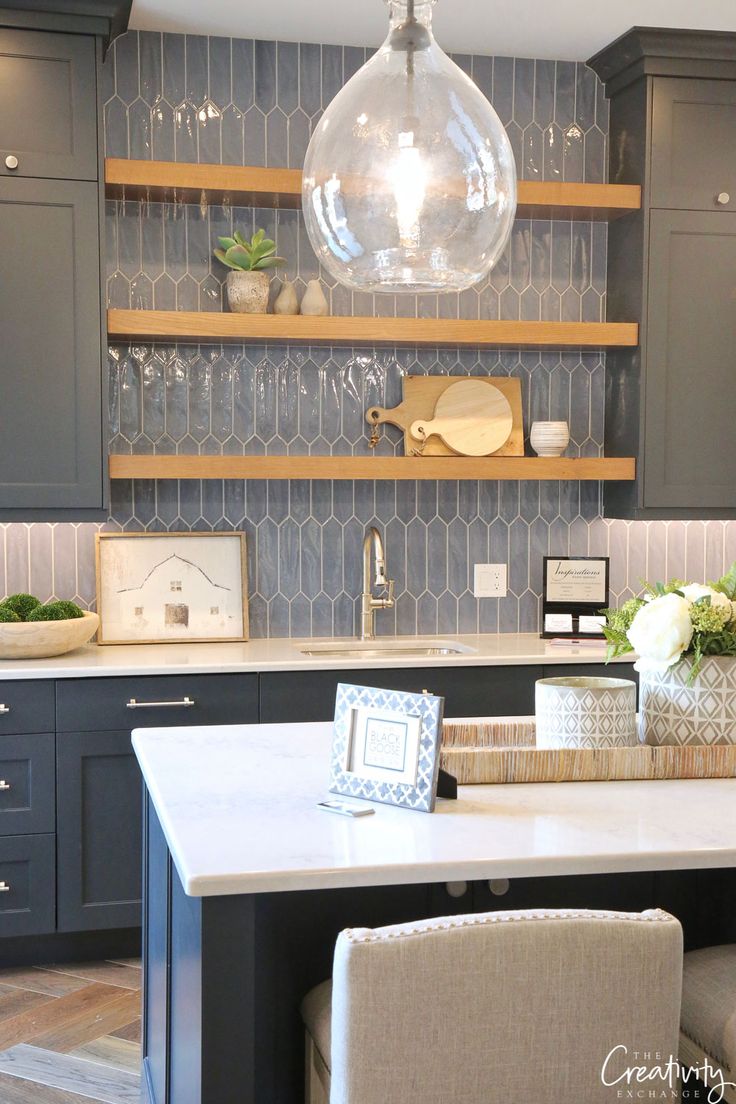 a kitchen with gray cabinets and white counter tops