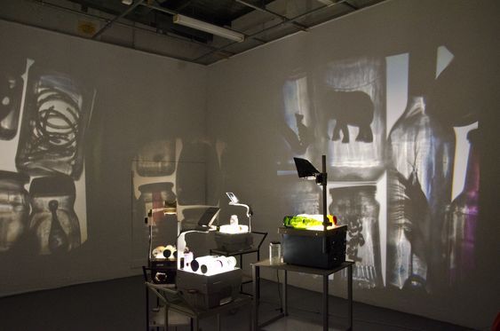 an art gallery with various sculptures on the walls and shadows projected on the wall behind them