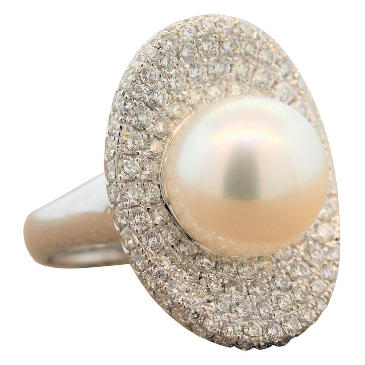 This characterful ring features a 12mm South Sea pearl in the center of a concave oval shape of this 18K white gold ring. The setting with 2.60 carats of shimmering round cut diamonds is reminiscent of a pearls shell. This cocktail ring is delicate as it is fun. Ring Size 6.75 (Sizable) Pearl Ring Designs, Pearl Ring Design, South Sea Pearl Ring, Diamond Gold Ring, Diamond Bracelet Design, Fancy Yellow Diamond, Pearl And Diamond Ring, Platinum Diamond Rings, Gold Cocktail Ring