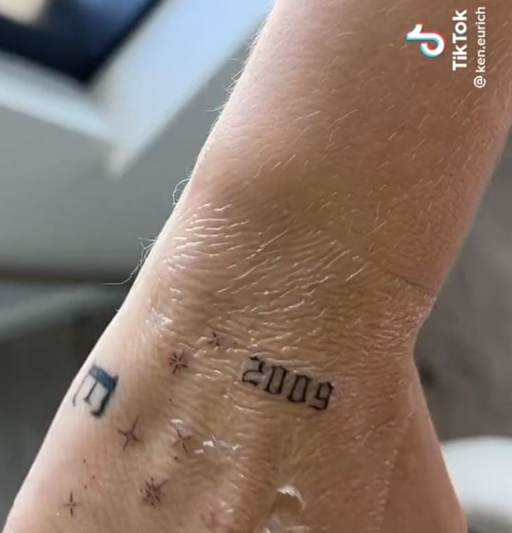 a person's hand with a tattoo on it that reads 2013 and has stars