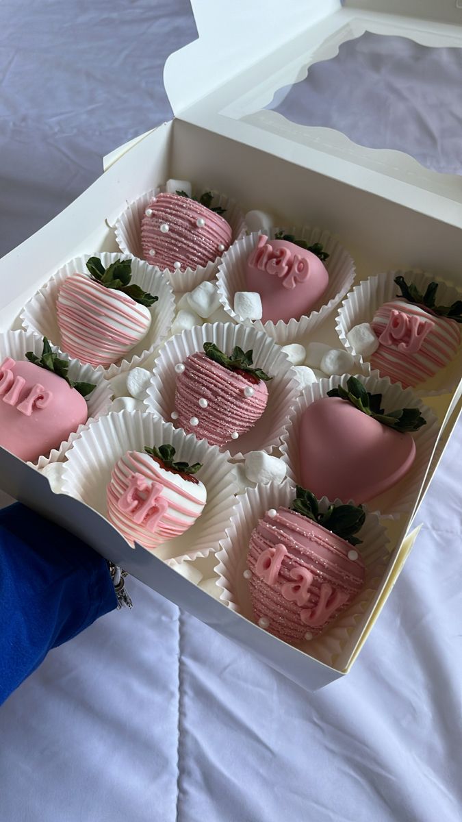 a box filled with pink and white chocolate covered strawberries