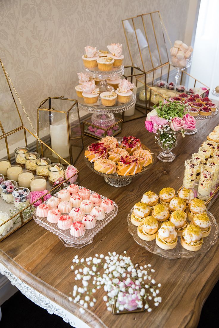 a table topped with lots of desserts and cupcakes on top of it