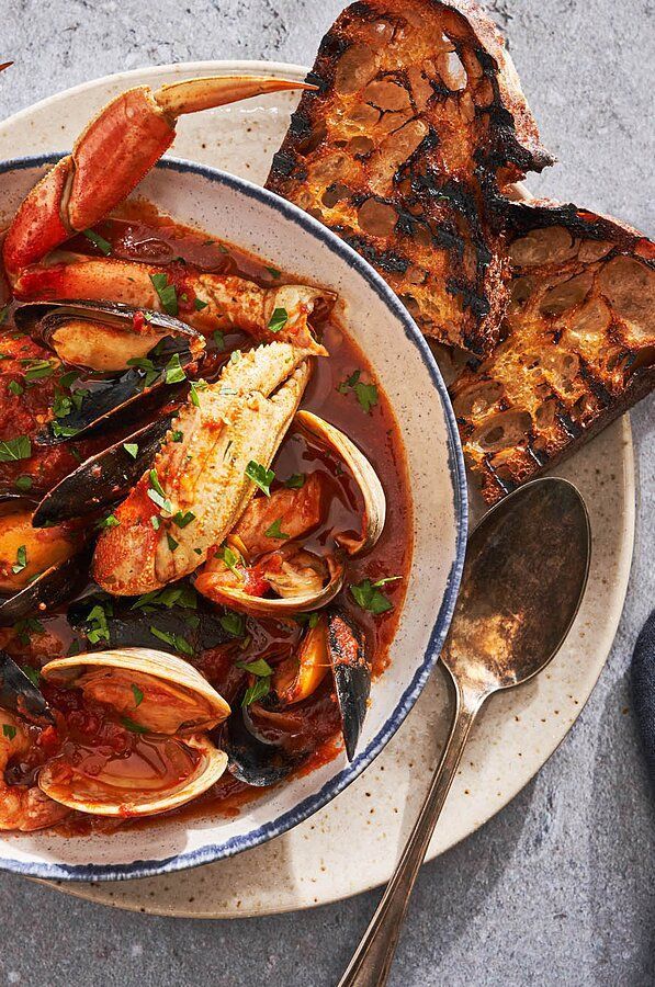 there is a plate of seafood and bread on the table with utensils next to it