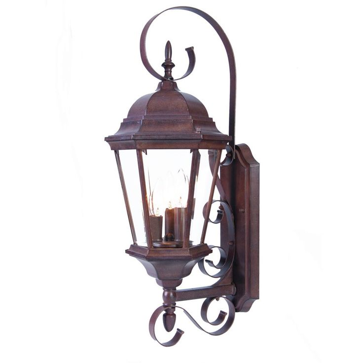 an old fashioned wall light with two lit candles on the front and back of it