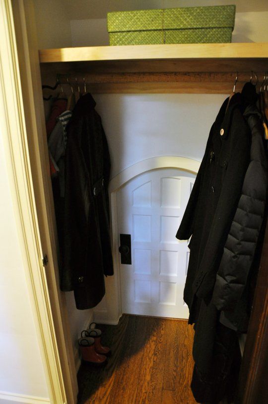 an open closet with coat racks and shoes