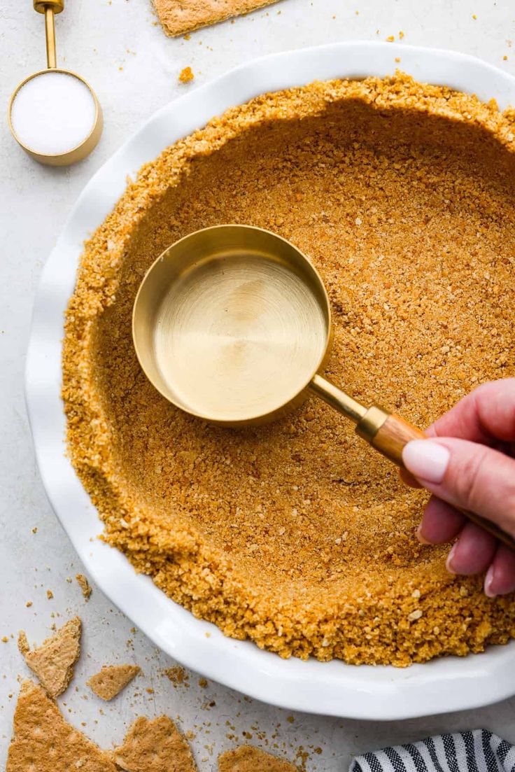 a person scooping some food out of a bowl with a metal spoon in it