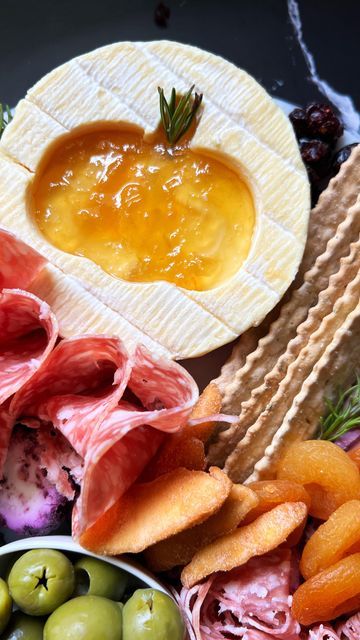 an assortment of food including crackers, olives, bread and other foodstuffs