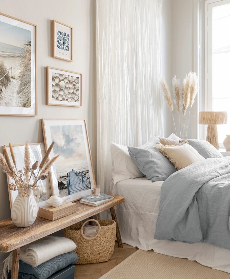 a bedroom with white walls and pictures on the wall above the bed, along with other decor items