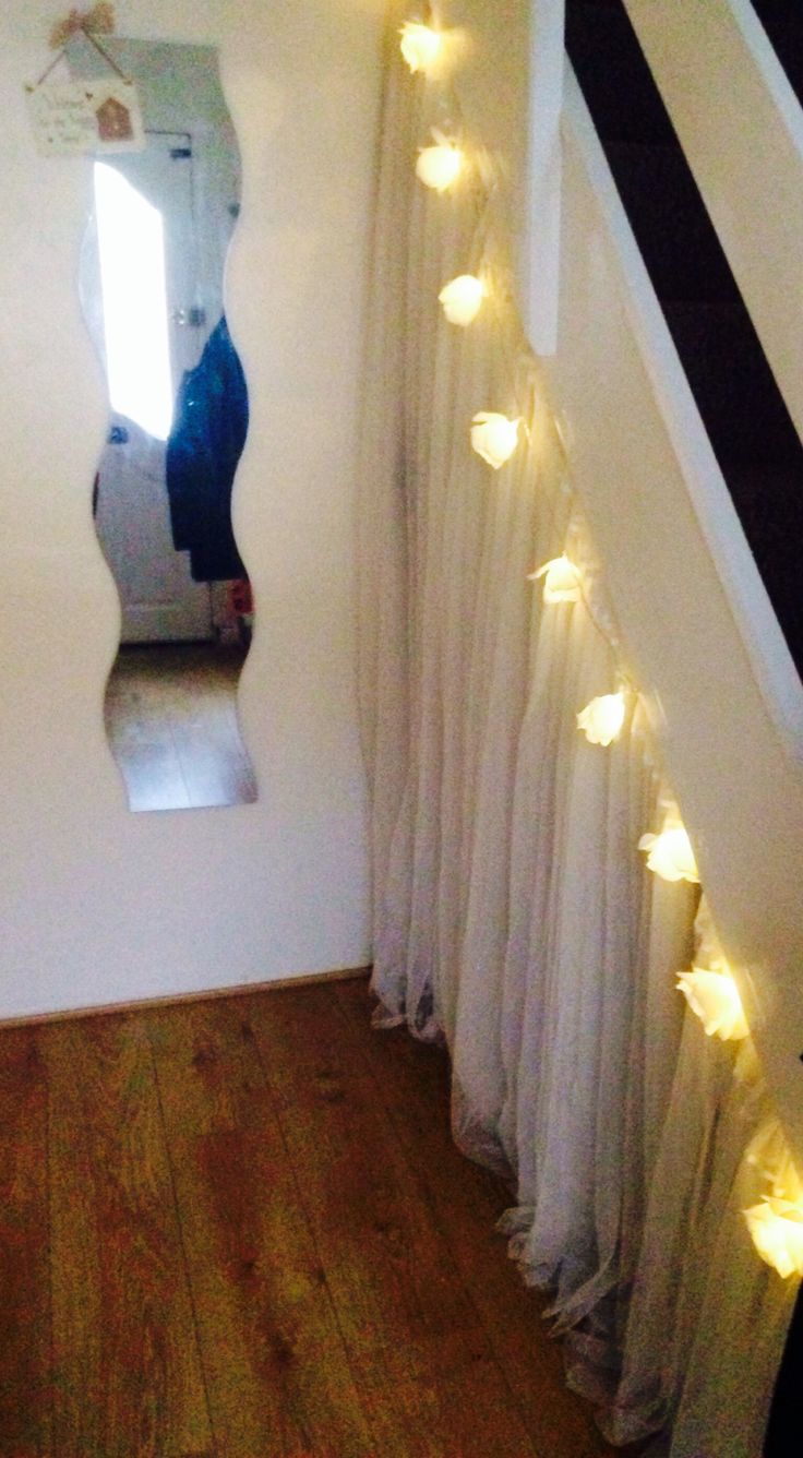 a mirror that is on the side of a wall with lights hanging from it's sides