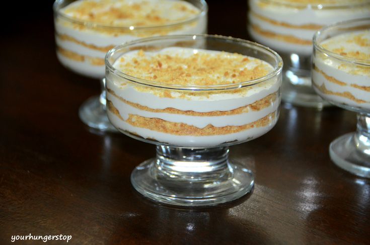 four desserts in small glass dishes on a table