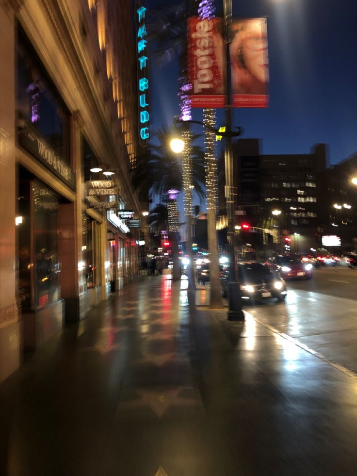 a city street at night with cars driving down it