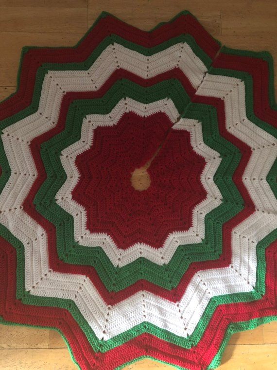 a crocheted blanket is laying on the floor with a clock in the center