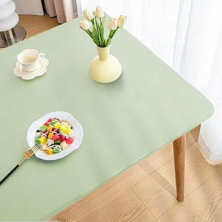 a green table topped with a plate of food and a vase filled with tulips