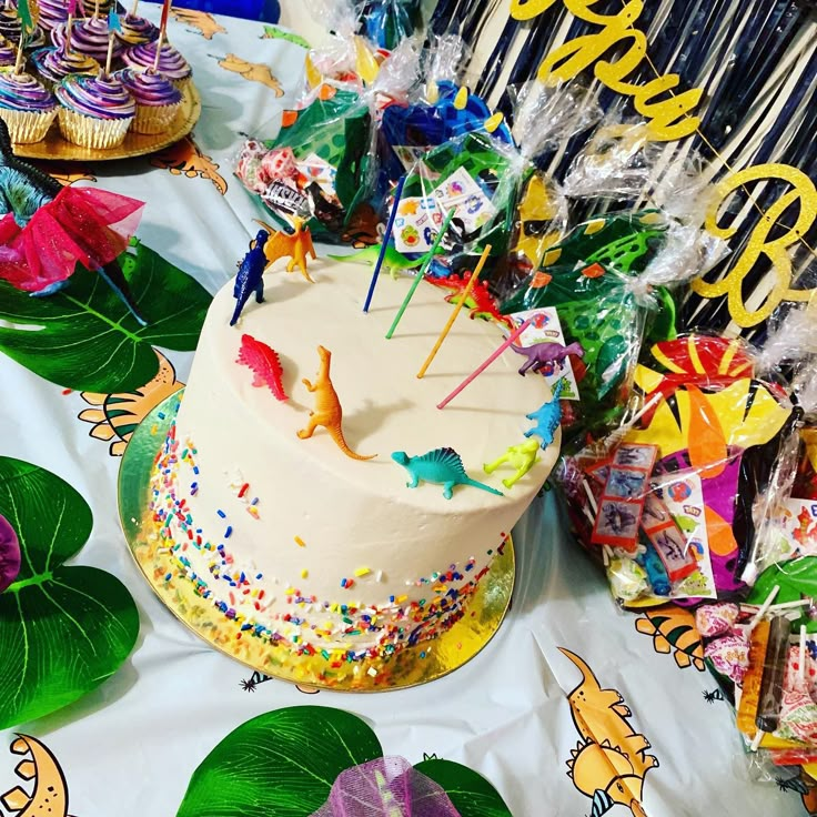 a birthday cake sitting on top of a table next to other desserts and candies