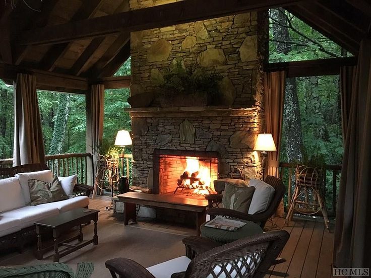 a living room with furniture and a fire place in the middle of it's fireplace