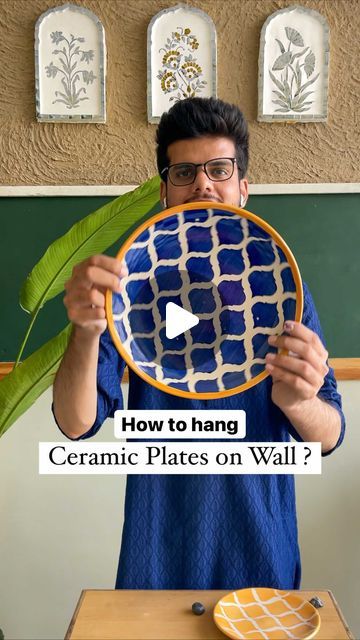 a man holding up a plate with the words how to hang ceramic plates on wall?