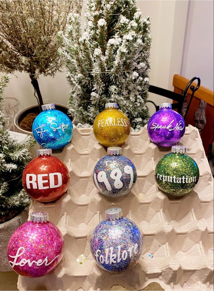 christmas ornaments on display in front of trees